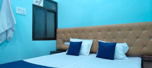 a blue room with a large bed with blue pillows at Shri Shiva Homestay by VM Stays in Varanasi