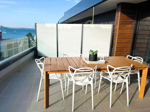 a wooden table and chairs on a balcony at PIER POINT 3 Bedroom Deluxe Apartment located on The Geelong Waterfront - 106 in Geelong