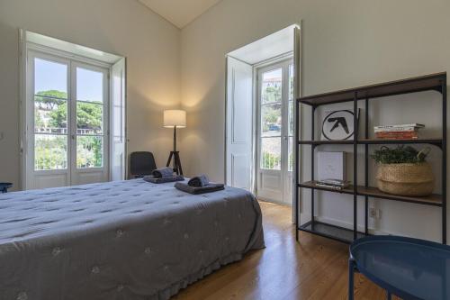 a bedroom with a large bed and two windows at Lagares 74 in Lisbon