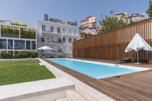 a swimming pool with an umbrella next to a building at Lagares 74 in Lisbon