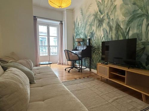 a living room with a couch and a flat screen tv at A cozy hideout in Lisbon