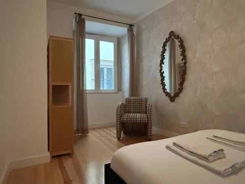 a bedroom with a bed and a mirror and a chair at A cozy hideout in Lisbon