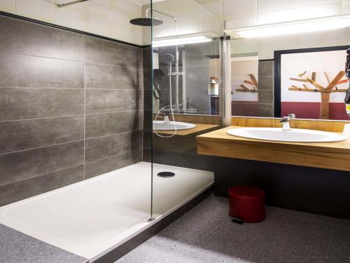 a bathroom with a shower and a sink at Greet Hôtel Castres Saix in Saix