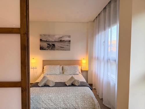 een slaapkamer met een bed en een groot raam bij El Loft de Salàs - L'Amfitriona in Salás de Pallás