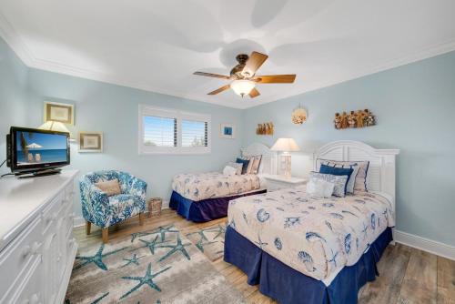 una camera da letto con due letti e un ventilatore a soffitto di Sandpiper Beach #405 a Sanibel