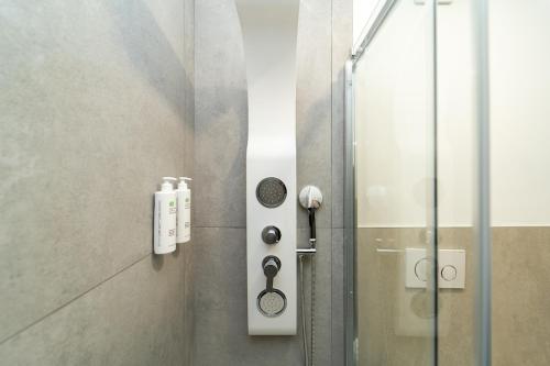 una cabina doccia con porta in vetro con doccia di Spacious apartment with WiFi and AC & parking a Milano