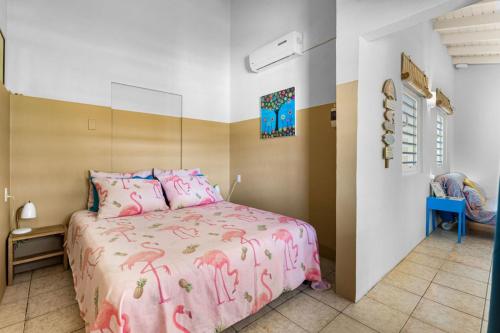 een slaapkamer met een roze bed met roze flamingo's bij Barefoot Bonaire in Kralendijk