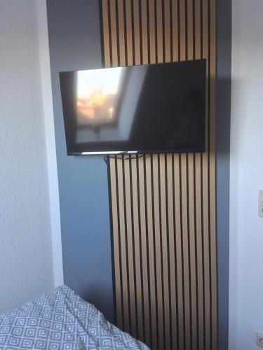 een flatscreen-tv die aan de muur hangt bij Hotel & Restaurant Hasa in Gernrode - Harz