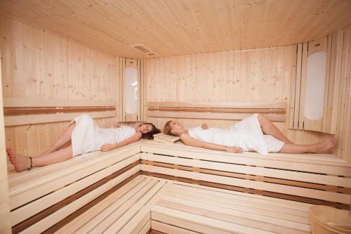 two people laying in a sauna at Penzion Motyl in Bešeňová