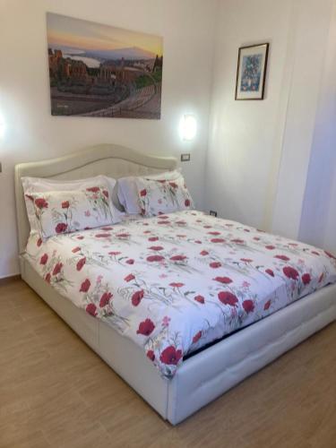 a bedroom with a bed with a floral bedspread at Elegant mini appartments Floridia close to the center private parking in Taormina