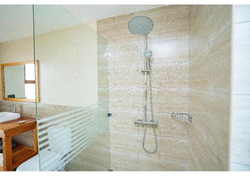 a shower in a bathroom with a glass door at Inchorroi Cottages - champagne ridge in Oloyaingalani