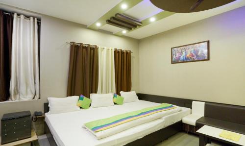 Un dormitorio con una cama blanca y una ventana. en Hotel Raj Garden , Pushkar, en Pushkar