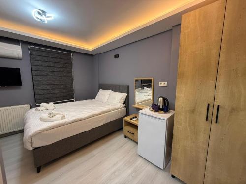 a small bedroom with a bed and a mirror at Atay Apart in Istanbul