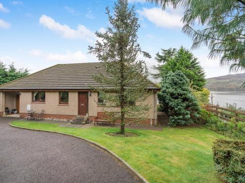 een huis met een boom naast een oprit bij Lochside View in Lochearnhead