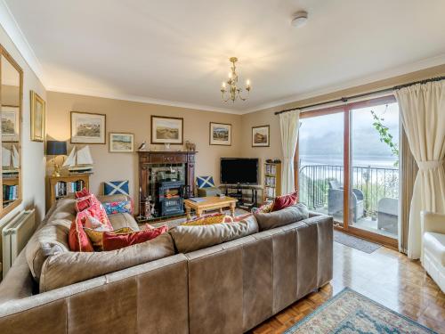 een woonkamer met een grote bank en een televisie bij Lochside View in Lochearnhead