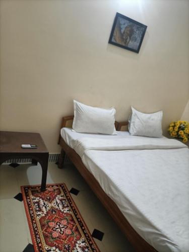 a small room with a bed and a table and a bed sidx sidx at Red king home stay in Bikaner