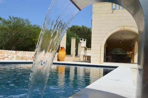 een fontein voor een zwembad bij B&b Aurasia in Ostuni