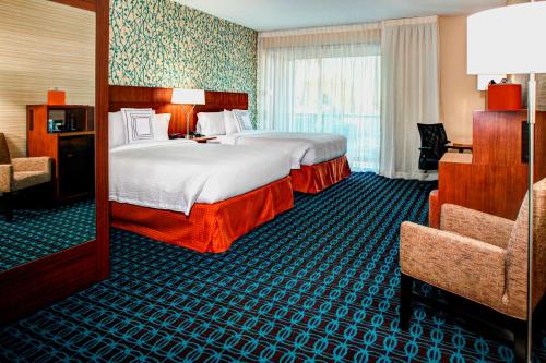 エル・セグンドにあるフェアフィールド イン & スイーツ バイ マリオット ロサンゼルス LAX エル セグンドのベッド2台と椅子があるホテルの部屋