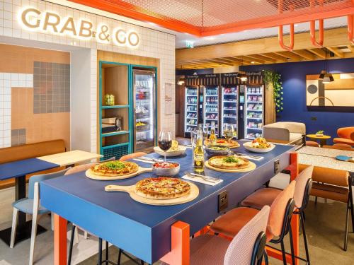 ein Restaurant mit einem langen Tisch mit Speisen in der Unterkunft ibis budget Manchester Airport T2 in Hale