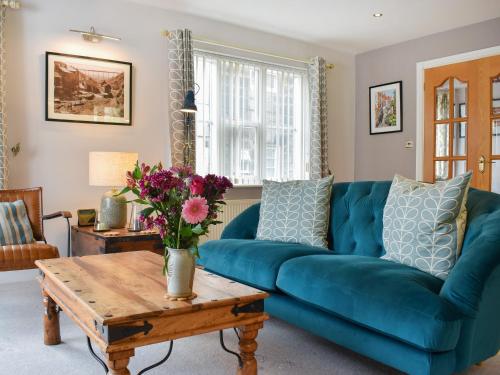 a blue couch in a living room with a table at Pilot Me Cottage in Staithes