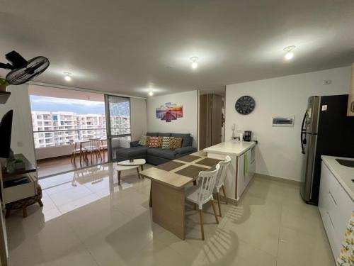 eine Küche und ein Wohnzimmer mit Sofa und Tisch in der Unterkunft Extraordinario Apartamento para Vacaciones en Ricaurte Cund in Ricaurte