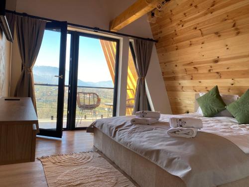 a bedroom with a bed with towels on it at Royal Hill Bran-A-Frame and Bungalows whit Hot Tub and Sauna in Sohodol