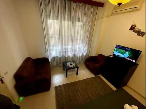 un soggiorno con divano, sedia e TV di The Perfect Location Studio! a Bucarest