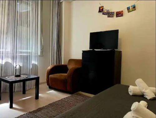 un soggiorno con un divano e una televisione di The Perfect Location Studio! a Bucarest