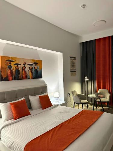 a bedroom with a large bed with orange pillows at Bella INN - Deluxe Master rooms with Balcony - No Smoking in Dubai