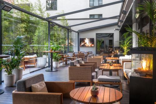 a restaurant with tables and chairs and fireplaces at SANA Berlin Hotel in Berlin