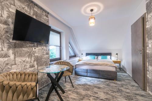 ein Schlafzimmer mit einem Bett und einem Fernseher an der Wand in der Unterkunft Apartamenty Sarnia 6A in Karpacz