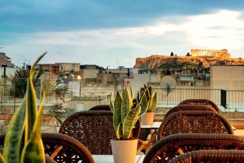 einen Tisch und Stühle mit Stadtblick in der Unterkunft Zeus Essence Athens Central, former Athens Key in Athen