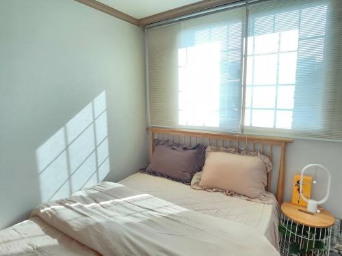 a small bedroom with a bed and a window at Hanok Story in Jeonju