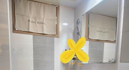 a yellow flower on the wall of a bathroom at Hanok Story in Jeonju