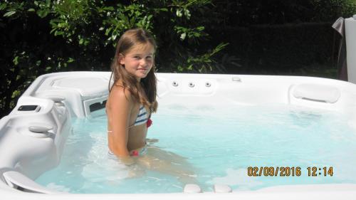 a little girl is standing in a swimming pool at Lake&Nature Hotel Gloria in Molveno