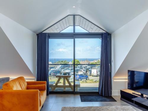 Una sala de estar con un sofá y una ventana grande. en Sea Skapya - Uk50178, en Helston