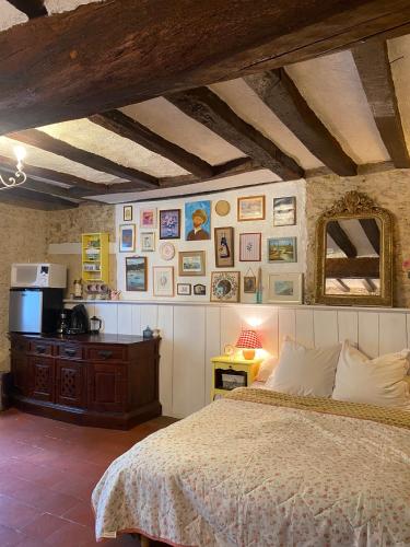a bedroom with a bed and a dresser and pictures on the wall at La Suzannerie in Vivoin