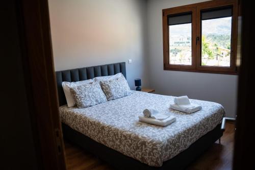 a bedroom with a bed with two towels on it at Chalé da Boucinha in Celorico de Basto