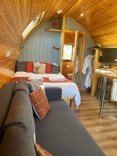 a living room with two beds and a couch at Mill House Farm Pods- Jackdaws Den in Pilling