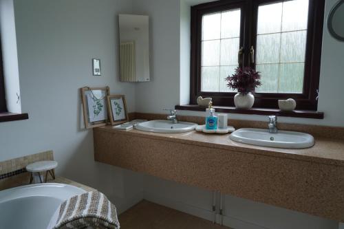 a bathroom with two sinks and a window at Carreg Llwyd in Caerphilly