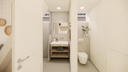 a small bathroom with a sink and a toilet at Skip Inn Strandhuisjes in Katwijk aan Zee