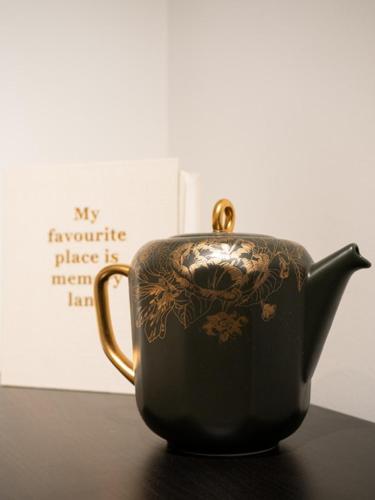 a black and gold tea pot sitting on a table at 4P boetiek apt met tuin bij Fontys en klooster in Tilburg