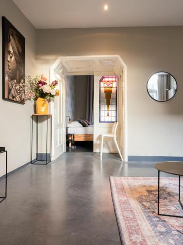 a living room with a room with a bed and a table at 4P boetiek apt met tuin bij Fontys en klooster in Tilburg