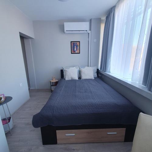 una camera da letto con un letto con un piumone blu di Yantra Tower Studio Maya a Gabrovo