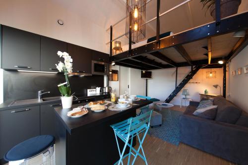 Una cocina y una sala de estar con un loft. en Appart Hotel Eugenie, en Louhans