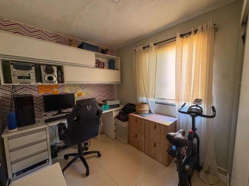 een kamer met een bureau met een computer en een stoel bij Jardins Mangueiral in Brasilia