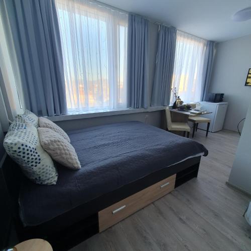 una camera da letto con un letto con cuscini e una finestra di Yantra Tower Studio Maya a Gabrovo