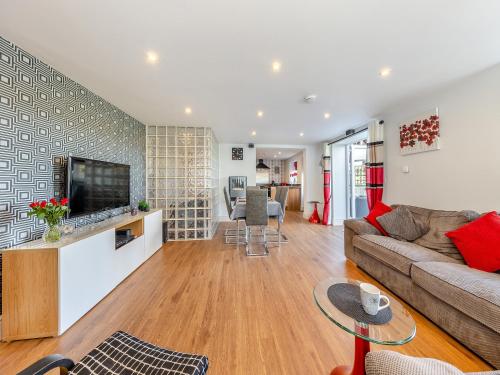 een woonkamer met een bank en een tv bij Ty Llyn Cottage in Brynteg