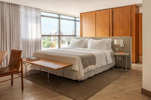 Una habitación de hotel con una cama grande y una mesa. en Nomaa Hotel, en Curitiba
