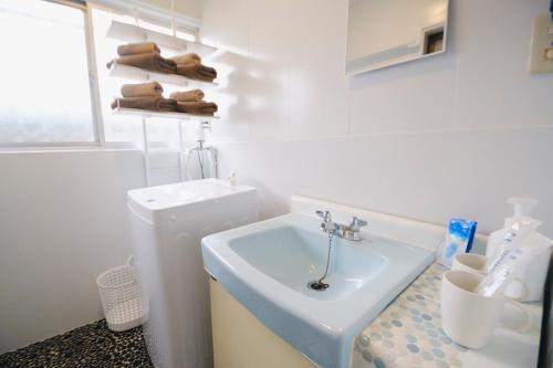 a white bathroom with a sink and a toilet at Oharama House in Nasushiobara